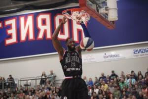 Harlem Globetrotters player Bulldog Mack dunks a basketball.